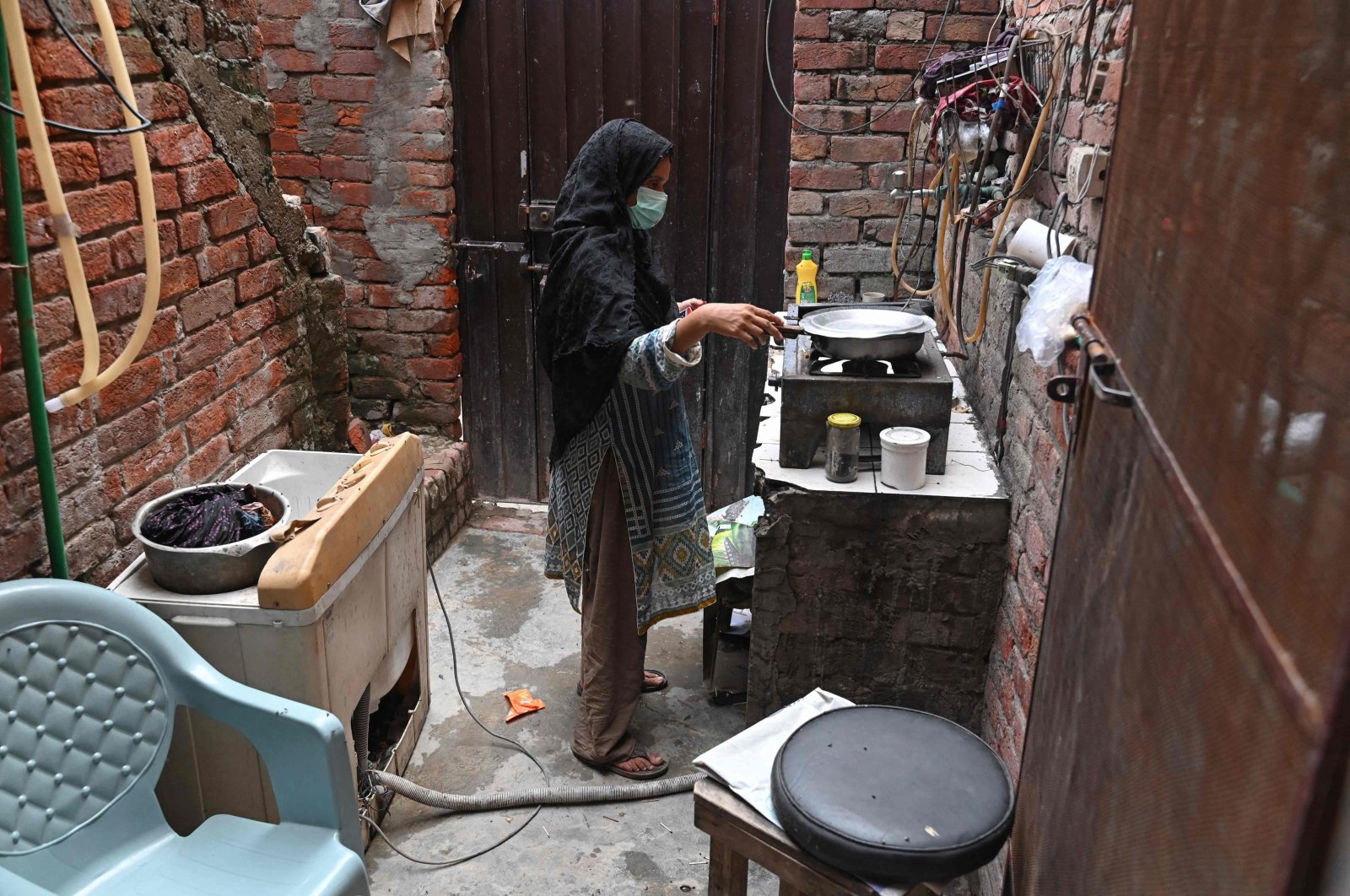 Lubna Babar, a former factory worker cooks during an interview with AFP at her house in Lahore, Pakistan, July 25, 2023. (AFP Photo)
