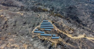 An aerial view of solar panels among charred trees, as a wildfire burns on the island of Rhodes, Greece July 27, 2023. (Reuters Photo)