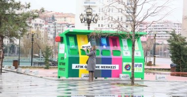 A woman dumps waste at a garbage collection point where different garbage is required to be dumped separately as part of zero waste project in Keçiören, Ankara, Feb. 13, 2019. (IHA Photo)