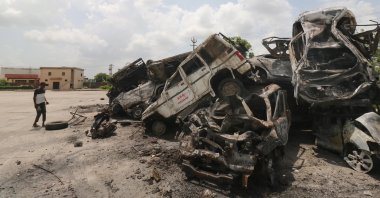 A man stands next to burnt vehicles dumped near a bus stand in the aftermath of riots in Nuh, Haryana state, India, Aug. 1, 2023. (EPA Photo)