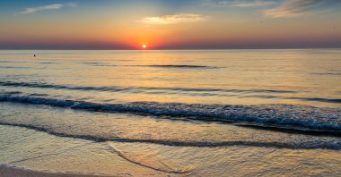 Vivid colors paint the sky as a beautiful sunrise emerges over the Black Sea, Aug. 8, 2023. (Shutterstock Photo)