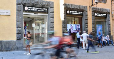 People pass in front of a branch of Monte dei Paschi di Siena (MPS), the oldest bank in the world, in Siena, Italy, Aug. 11 2021. (Reuters Photo)