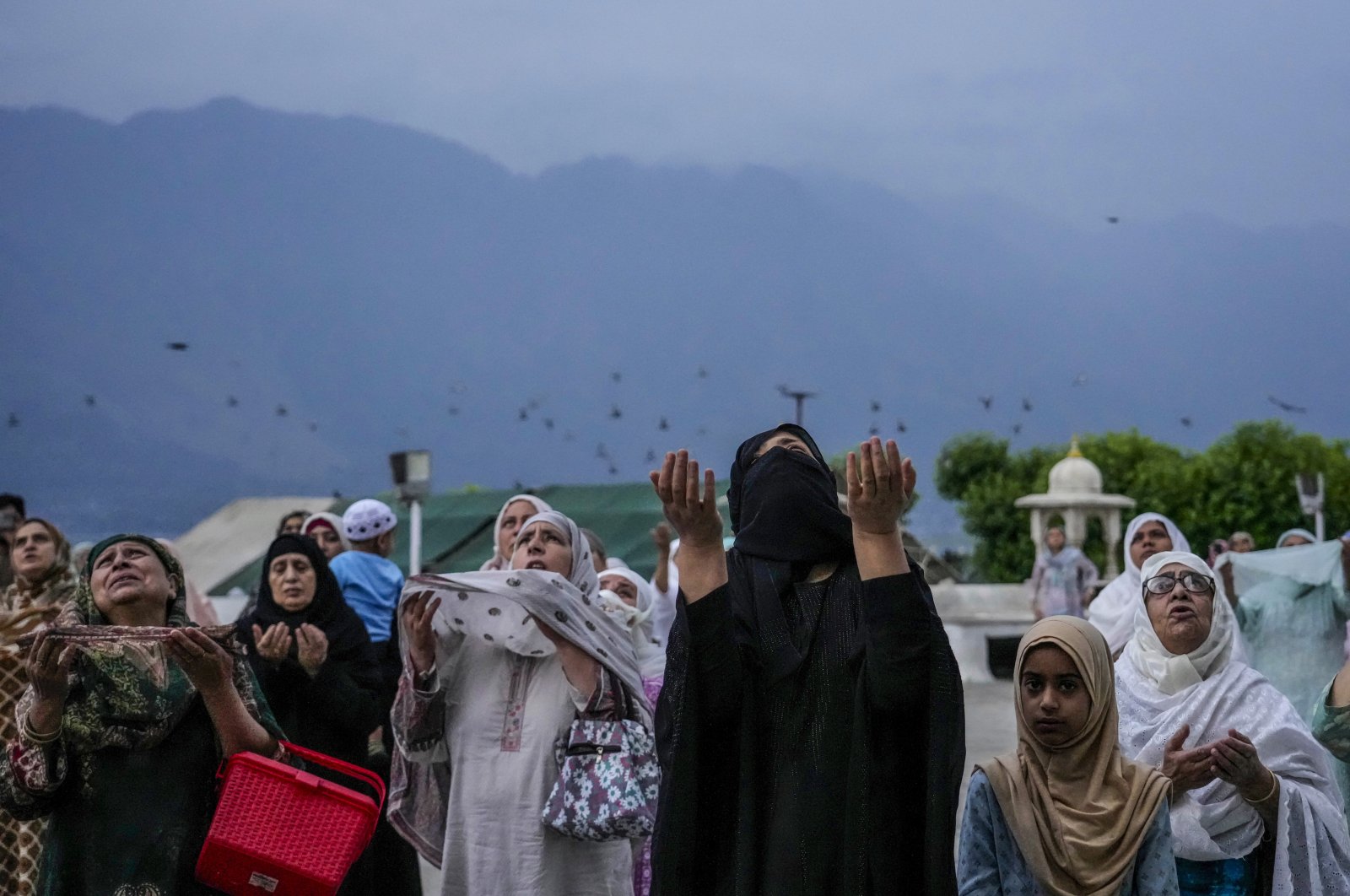 Kashmiri women raise their hands and pray during special prayers to observe the Martyr Day of the second Muslim Caliph Omar bin al-Khattab, in Srinagar, Indian controlled Kashmir, July 16, 2023. (AP Photo)
