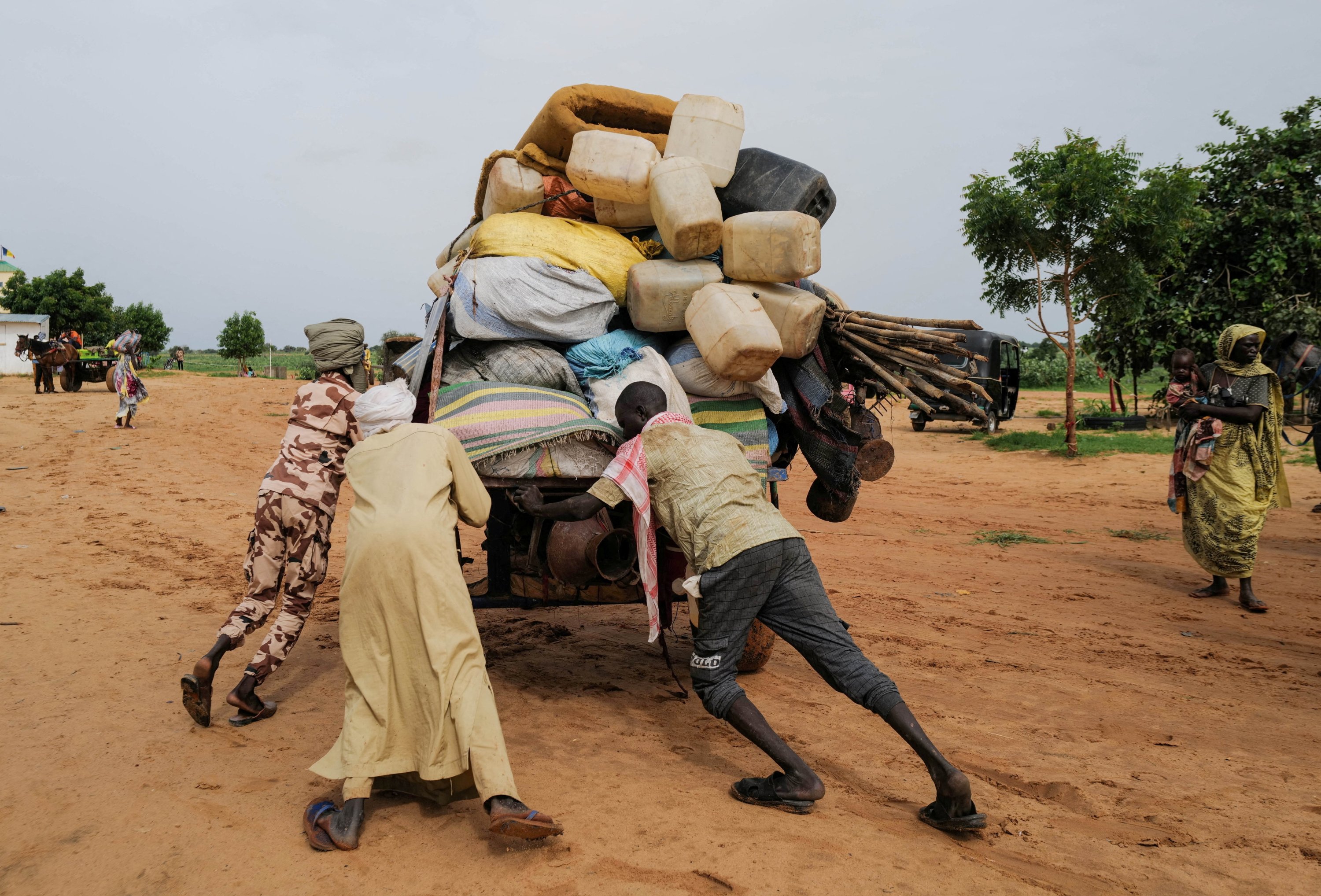 People push a cart while crossing the border between Sudan and Chad in Adre, Chad, Aug. 4, 2023. (Reuters Photo)