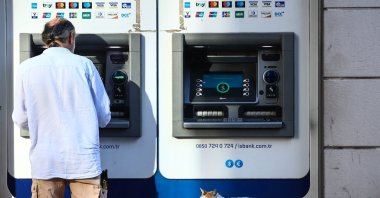 A stray cat sleeps in front of an ATM in Istanbul, Türkiye, Aug. 8, 2023. (EPA Photo)