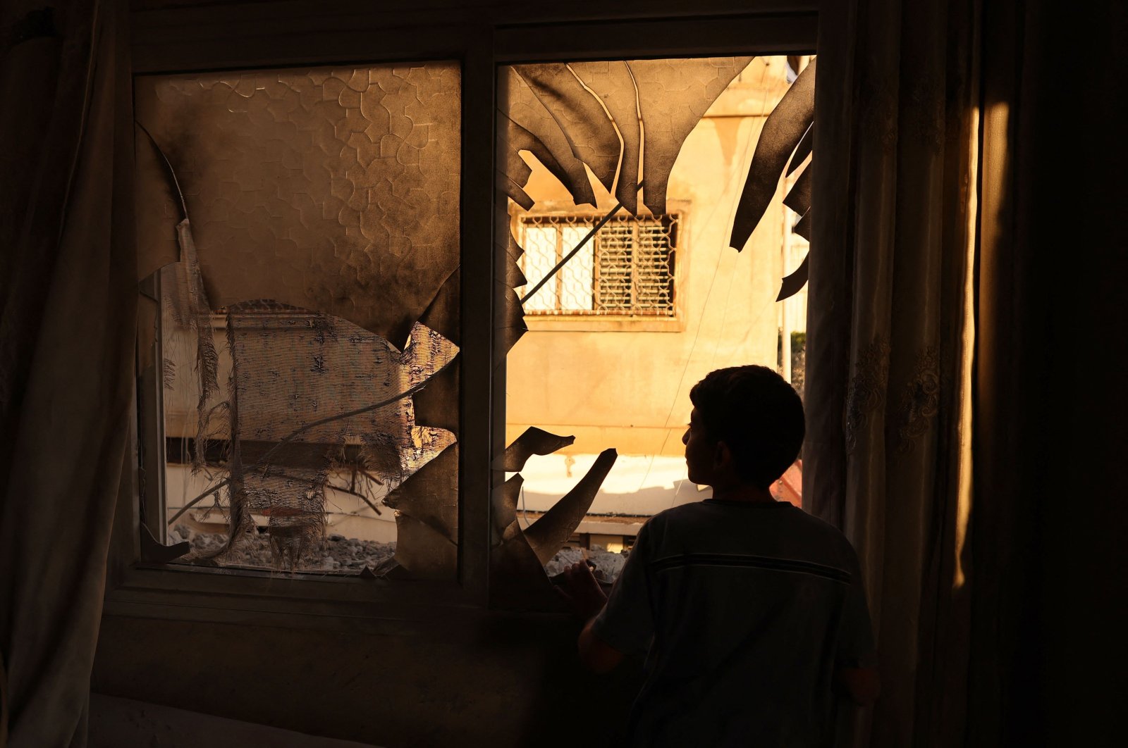 A youth inspects the remains of a house demolished by Israeli soldiers at the Askar refugee camp for Palestinian refugees east of Nablus in the occupied West Bank, Palestine, Aug. 8, 2023. (AFP Photo)