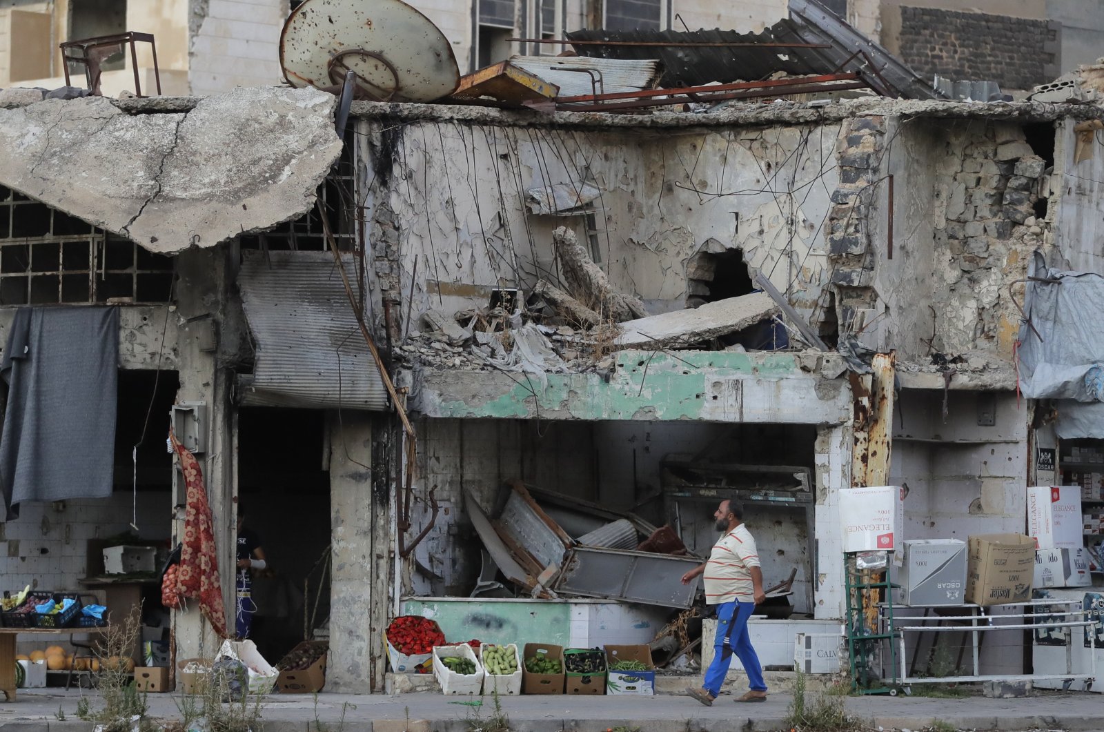 A man walks next to damaged buildings in the old town of Homs, Syria, Wednesday, Aug. 15, 2018. (AP File Photo)