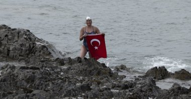 Turkish swimmer Aysu Türkoğlu unfurls a Turkish flag upon reaching Scotland, Aug. 9, 2023. (AA Photo)