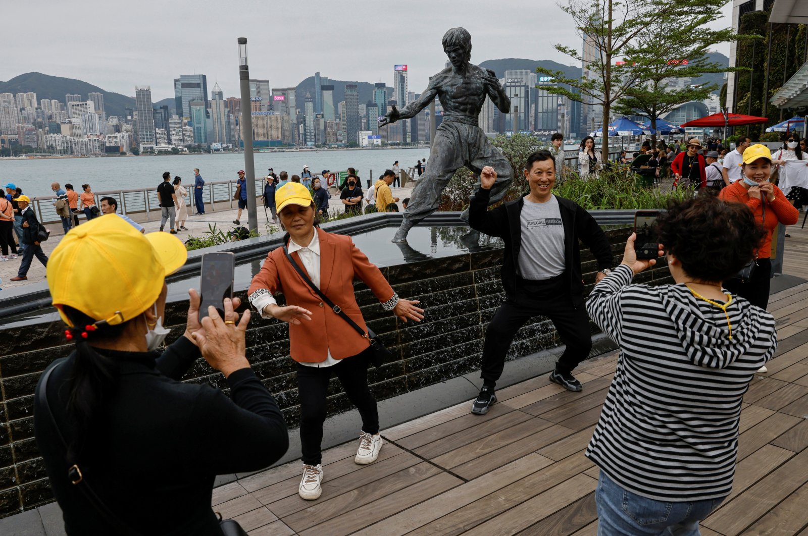 Chinese tourists pose for photos in front of a statue of the martial artist and actor Bruce Lee, on the Avenue of Stars attraction near the Tsim Sha Tsui waterfront, in Hong Kong, China, April 26, 2023. (Reuters Photo)