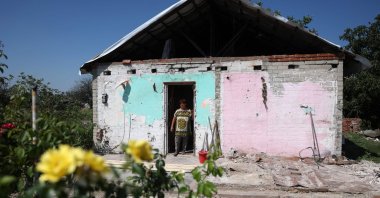 A local resident looks out from her damaged house in Topol's'ke village, Kharkiv region, Aug. 5, 2023. (AFP Photo)
