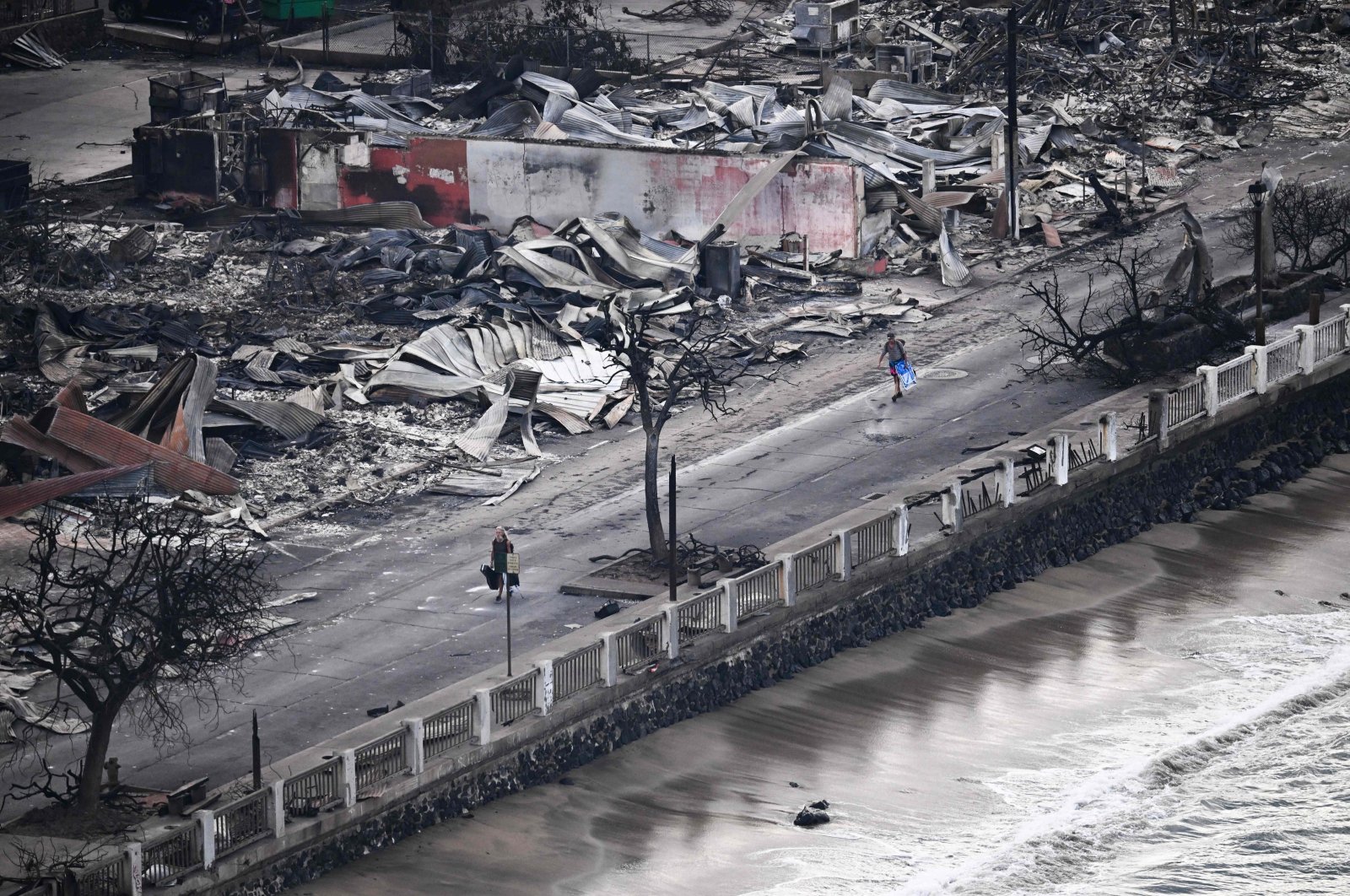 A person walking past destroyed buildings in Lahaina in the aftermath of wildfires in western Maui, Hawaii, Aug. 10, 2023. (AFP Photo)