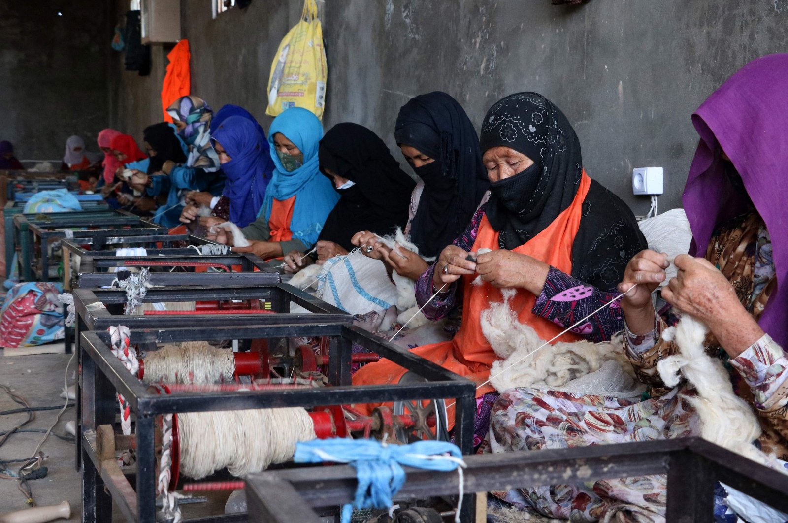 Afghan women spin wool into yarn at a traditional factory in the Herat province of Jibrail district, Afghanistan, Aug. 7, 2023. (AFP Photo)