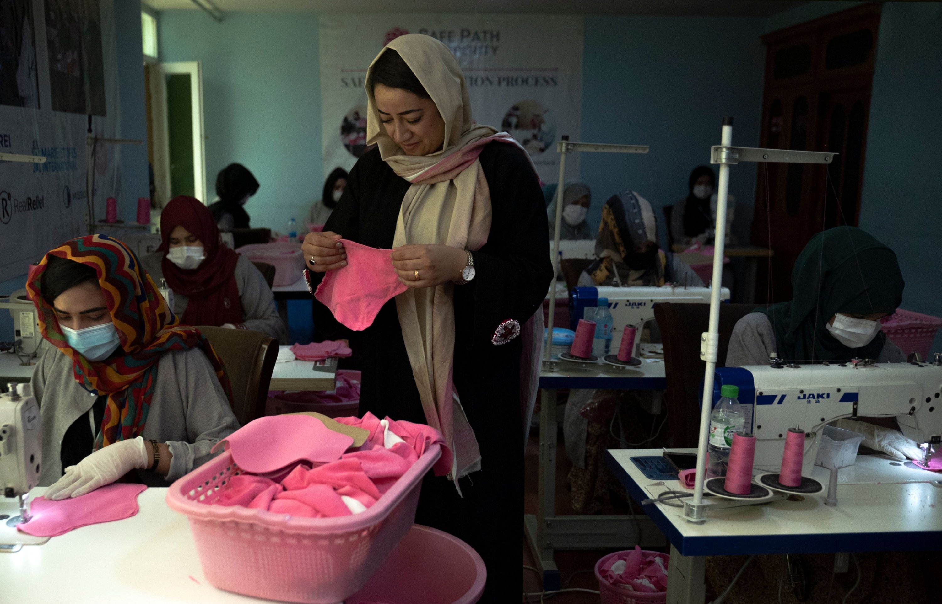 Arezo Osmani (C), owner of Safe Path Prosperity Social Enterprise inspects a fabric sanitary pad in her tailor workshop in Kabul, Afghanistan, July 31, 2023. (AFP Photo)