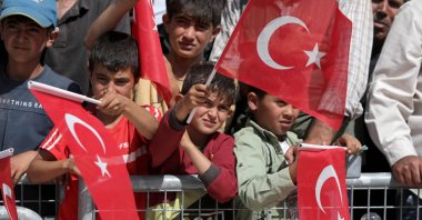 Syrian children wave Turkish flags as they attend the inauguration of a Qatari-funded Turkish housing complex project for the internally displaced, Ghandoura area, Jarablus, Syria, May 24, 2023. (AFP Photo)