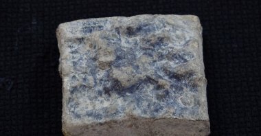 During excavations at the Roman-era nymphaeum to the east of the Agora in the Assos archaeological site, a lead weight dating back 2,300 years to the 3rd century B.C. and weighing 320 grams was discovered, Çanakkale, Türkiye, Aug. 15, 2023. (IHA Photo)