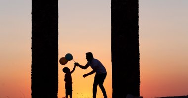 A father gives balloons to his son amid a stunning sunset in Cappadocia, Türkiye, Aug. 15, 2023. (AA Photo)