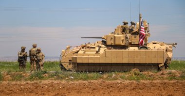 U.S. soldiers escort an armored tank part of a convoy carrying reinforcements for U.S. forces in regions controlled by terrorist group PKK/YPG in Deir ez-Zor, northern Syria, Aug. 15, 2023. (AA Photo)
