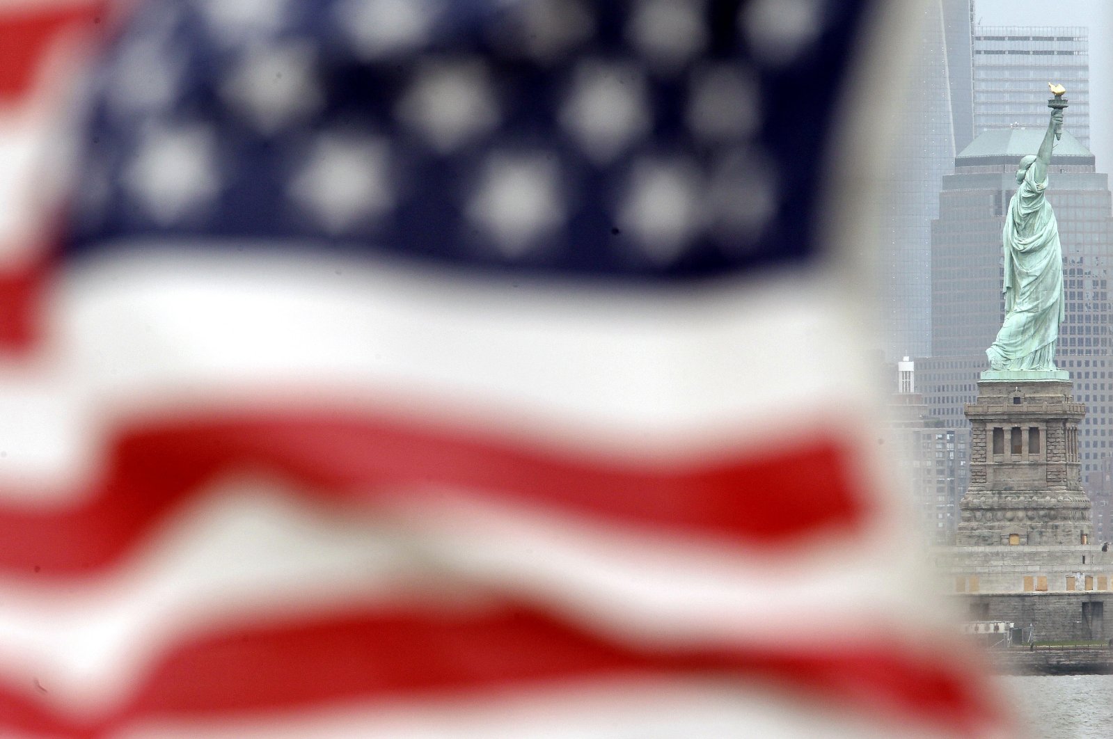 The Statue of Liberty is visible from Bayonne as a U.S. flag waves, New Jersey, U.S., May 8, 2012. (AP Photo)