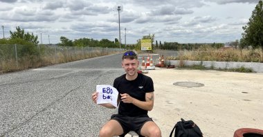 Joe Martin poses while hitchhiking to raise money for charity. (Photo by Kieran Brown)
