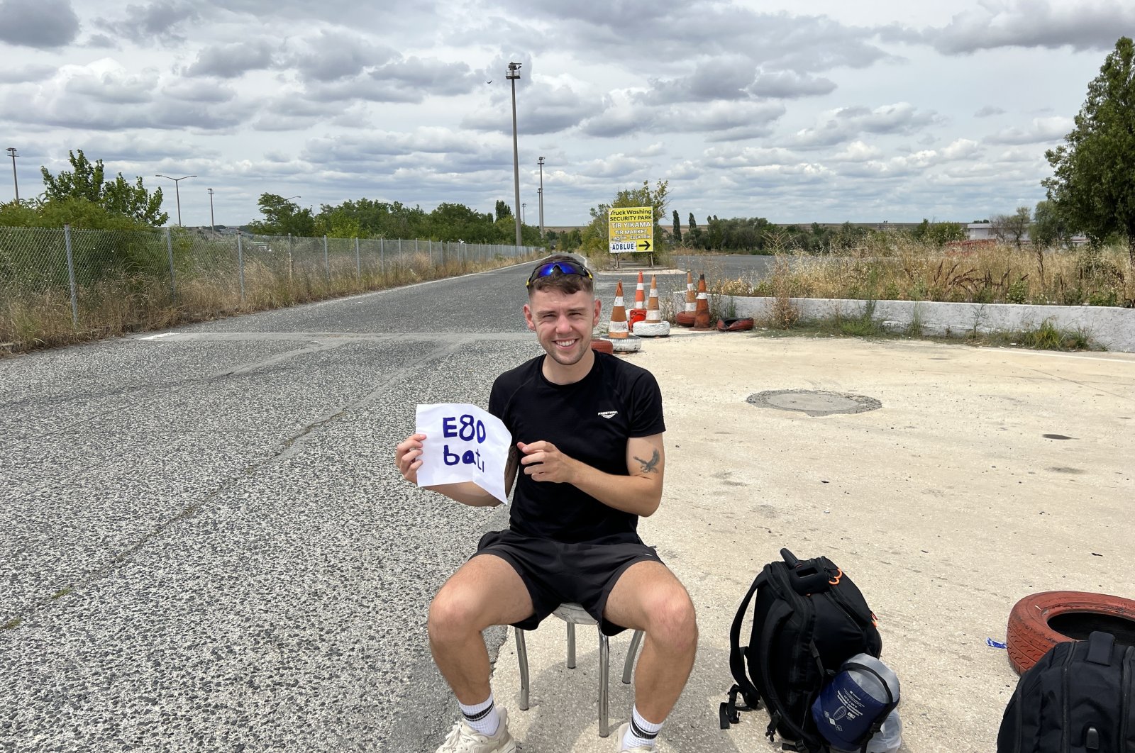 Joe Martin poses while hitchhiking to raise money for charity. (Photo by Kieran Brown)