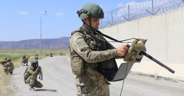 A guard near the wall dividing the Turkish-Iranian border scans the area via drone footage for illegal crossings, Van, eastern Türkiye, Aug. 16, 2023. (AA Photo)