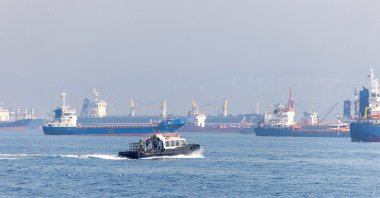 The Joint Coordination Centre officials sail through a cargo ship waiting to pass the Bosporus off the shores of Yenikapı during a misty morning in Istanbul, Türkiye, Oct. 31, 2022. (Reuters File Photo)