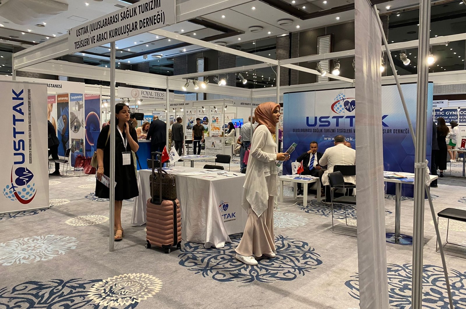 People are photographed close to the stand of the International Health Tourism Facilities and Intermediary Organizations Association (USTTAK) at the Expo Health Tourism Fair, Istanbul, Türkiye, Aug. 16, 2023. (DHA Photo)