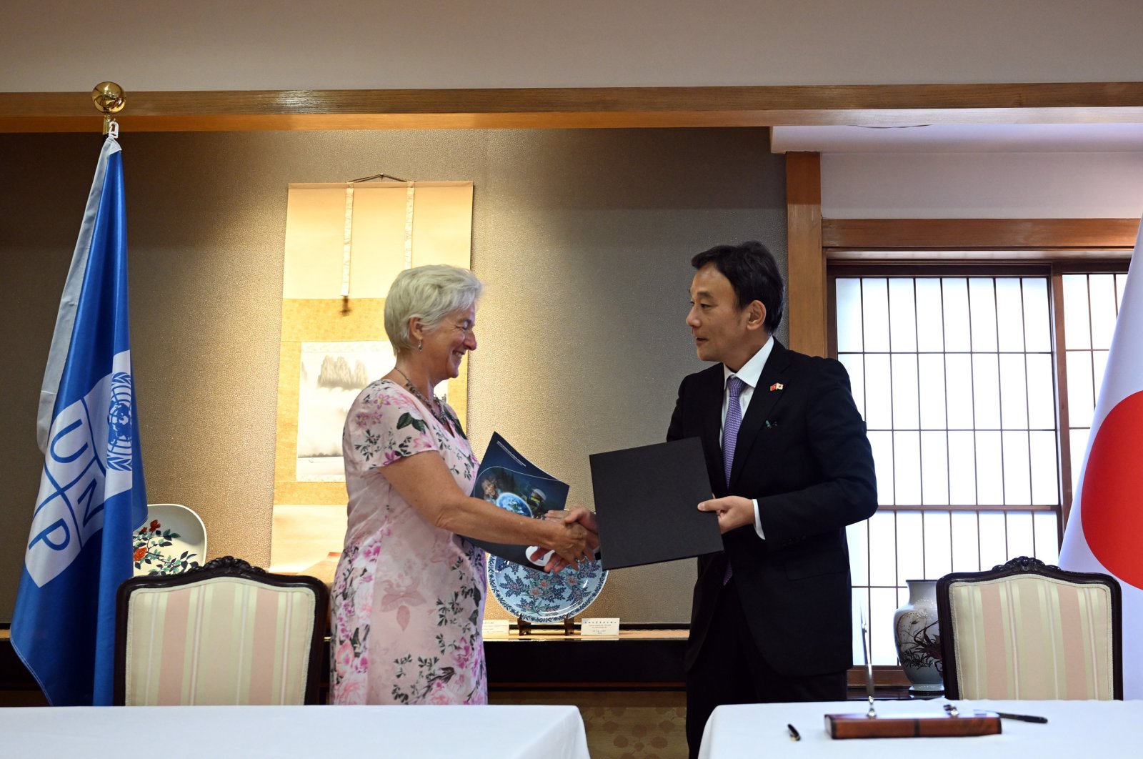 Ambassador Katsumata Takahiko (R) and UNDP Türkiye Resident Representative Louisa Vinton (L) shake hands at the signing agreement ceremony held at the Japanese Embassy in Ankara, Türkiye, Aug. 17, 2023. (AA Photo)