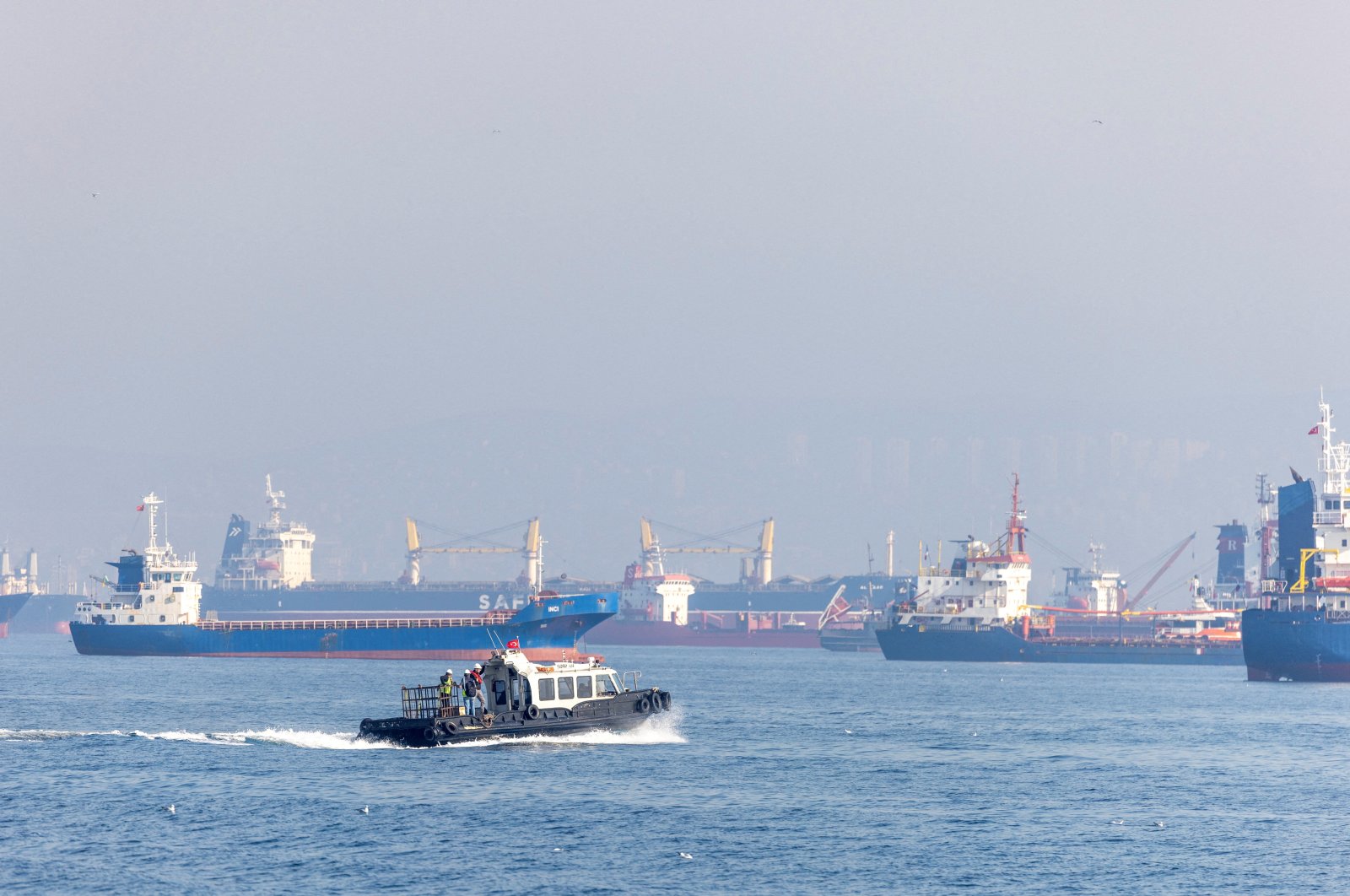 The Joint Coordination Centre officials sail through a cargo ship waiting to pass the Bosporus off the shores of Yenikapı during a misty morning in Istanbul, Türkiye, Oct. 31, 2022. (Reuters File Photo)