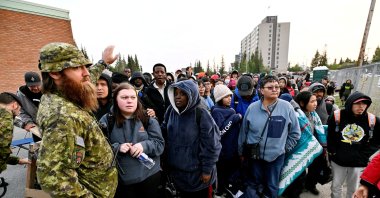 People line up outside of a local school to register to be evacuated, as wildfires threatened the Northwest Territories town of Yellowknife, Canada, Aug. 17, 2023. (Reuters Photo)