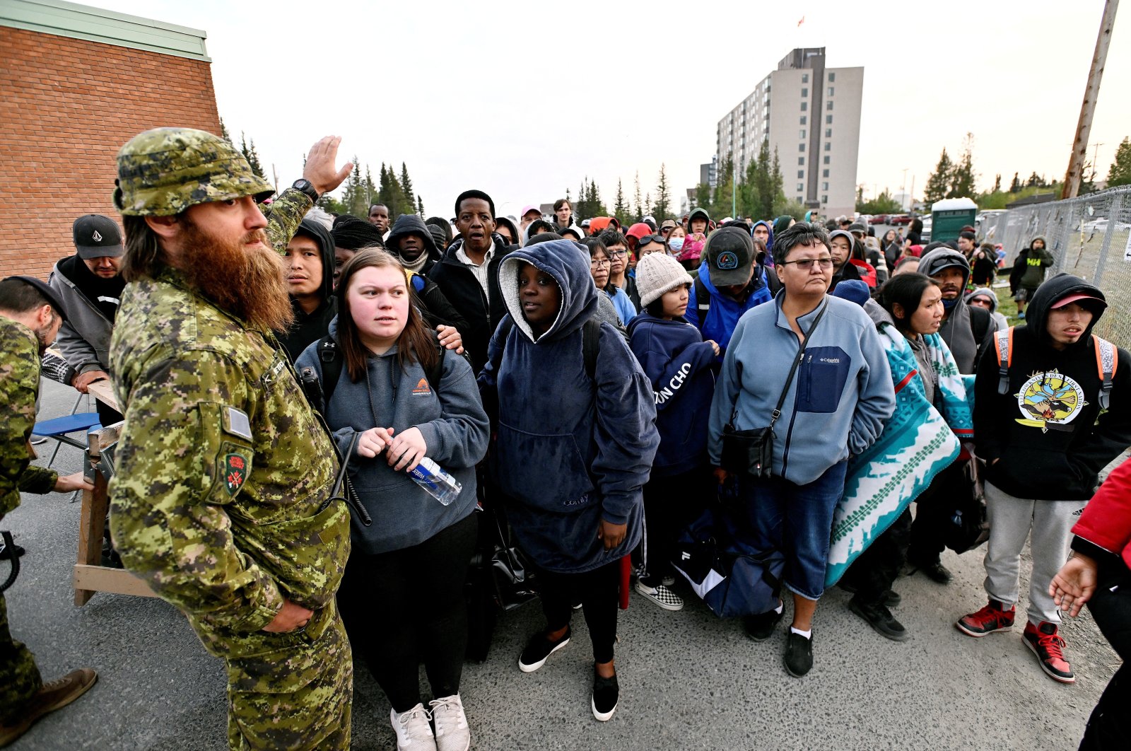 People line up outside of a local school to register to be evacuated, as wildfires threatened the Northwest Territories town of Yellowknife, Canada, Aug. 17, 2023. (Reuters Photo)