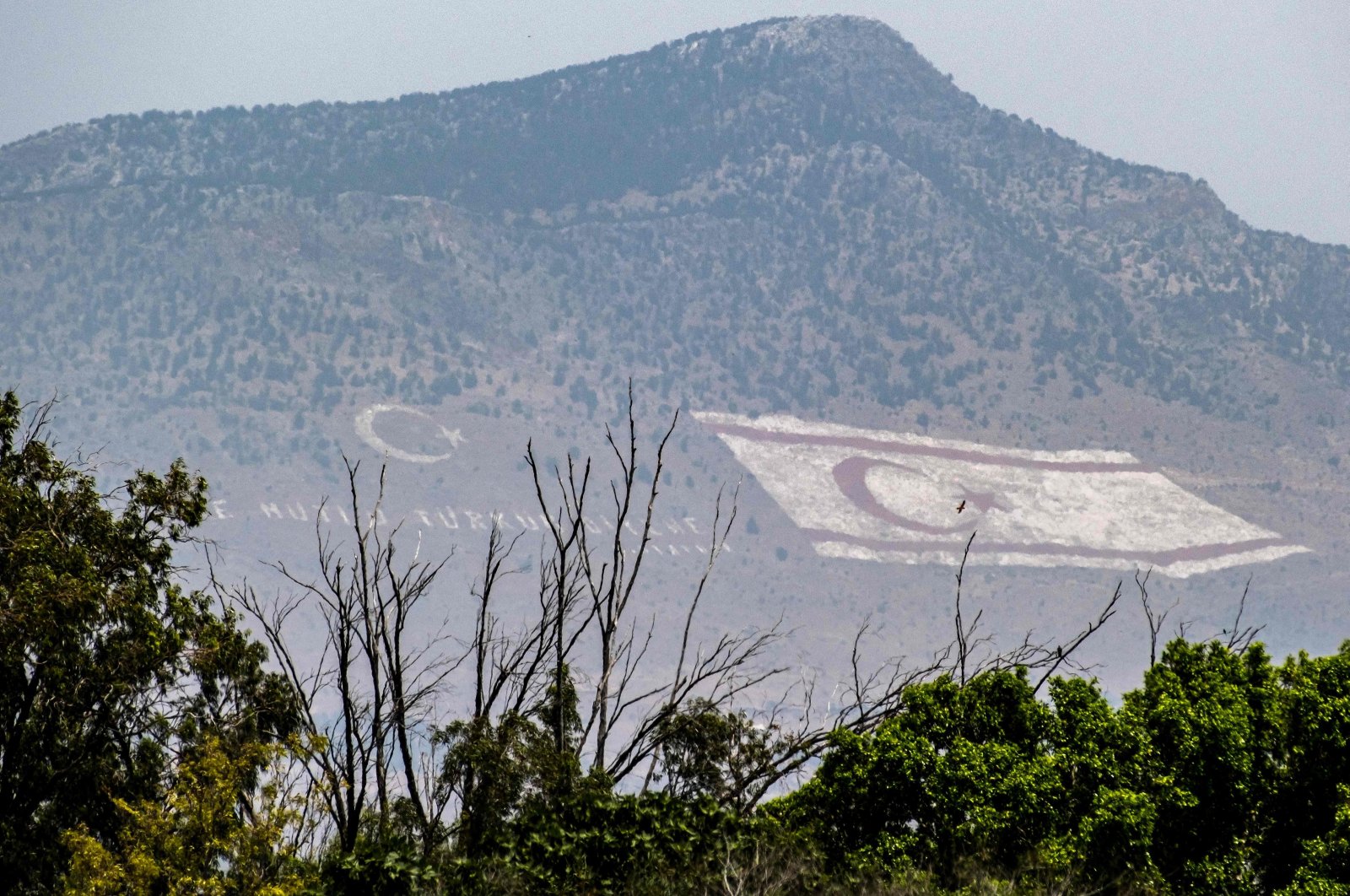 Flag of Turkish Cyprus painted on the mountain seen from the U.N. buffer zone, the island of Cyprus, July 4, 2023. (AFP Photo)