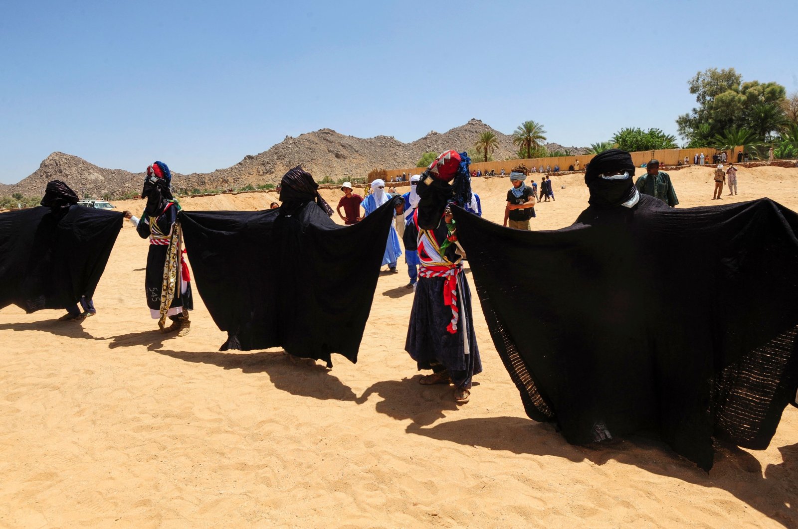 Men perform a traditional dance during the Sebeiba Festival, a yearly celebration of Tuareg culture, in the oasis town of Djanet in southeastern Algeria, July 29, 2023. (AFP Photo)