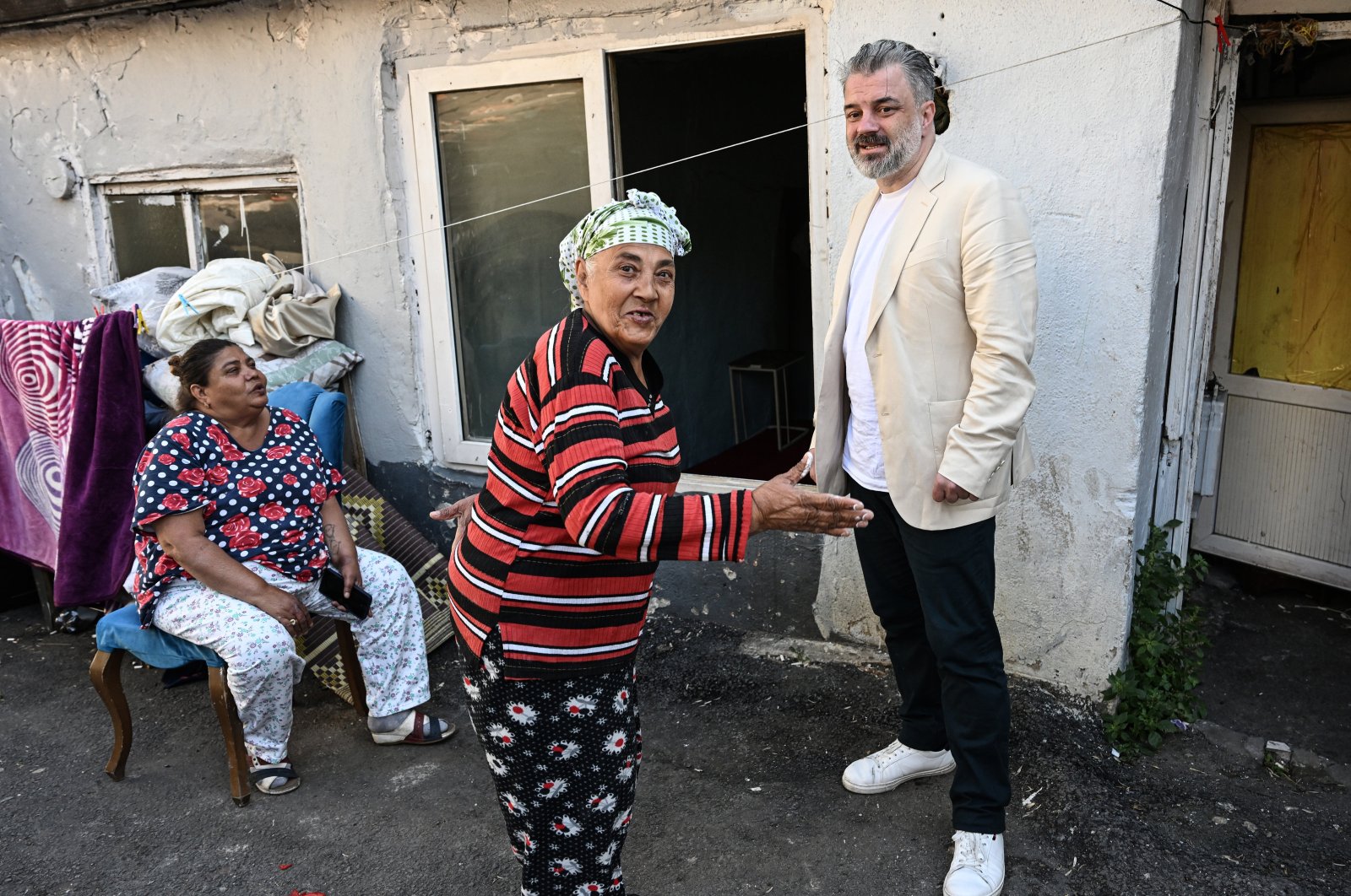 Head of Social Innovation at the Movement for Humanity and Civilization (IMH), Ercan Mayaer (R), chats with local Romani citizens during an interview with Anadolu Agency (AA) in Istanbul, Türkiye, Aug. 18, 2023. (AA Photo)