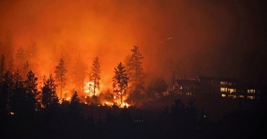 The McDougall Creek wildfire burns next to houses in the Okanagan community of West Kelowna, British Columbia, Canada, Aug. 19, 2023. (Reuters Photo)