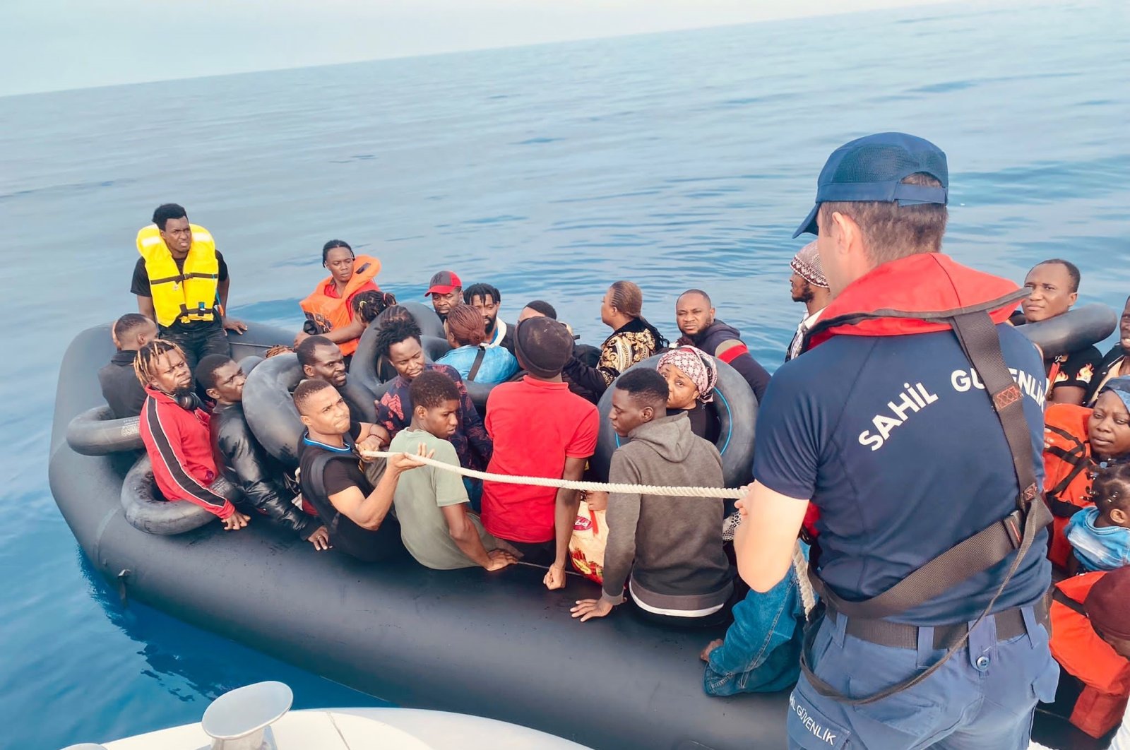 Turkish Coast Guard assist irregular migrants on a rubber boat, off the coast of Kuşadası, Aydın, western Türkiye, Aug. 20, 2023. (İHA Photo)
