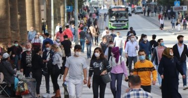 People wearing protective masks against COVID-19 walk on a street in Denizli, western Turkey, March 4, 2022. (IHA PHOTO)