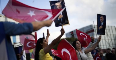 Supporters of President Recep Tayyip Erdoğan dance as they give handouts to commuters in Istanbul, Türkiye, May 23, 2023. (AP Photo)