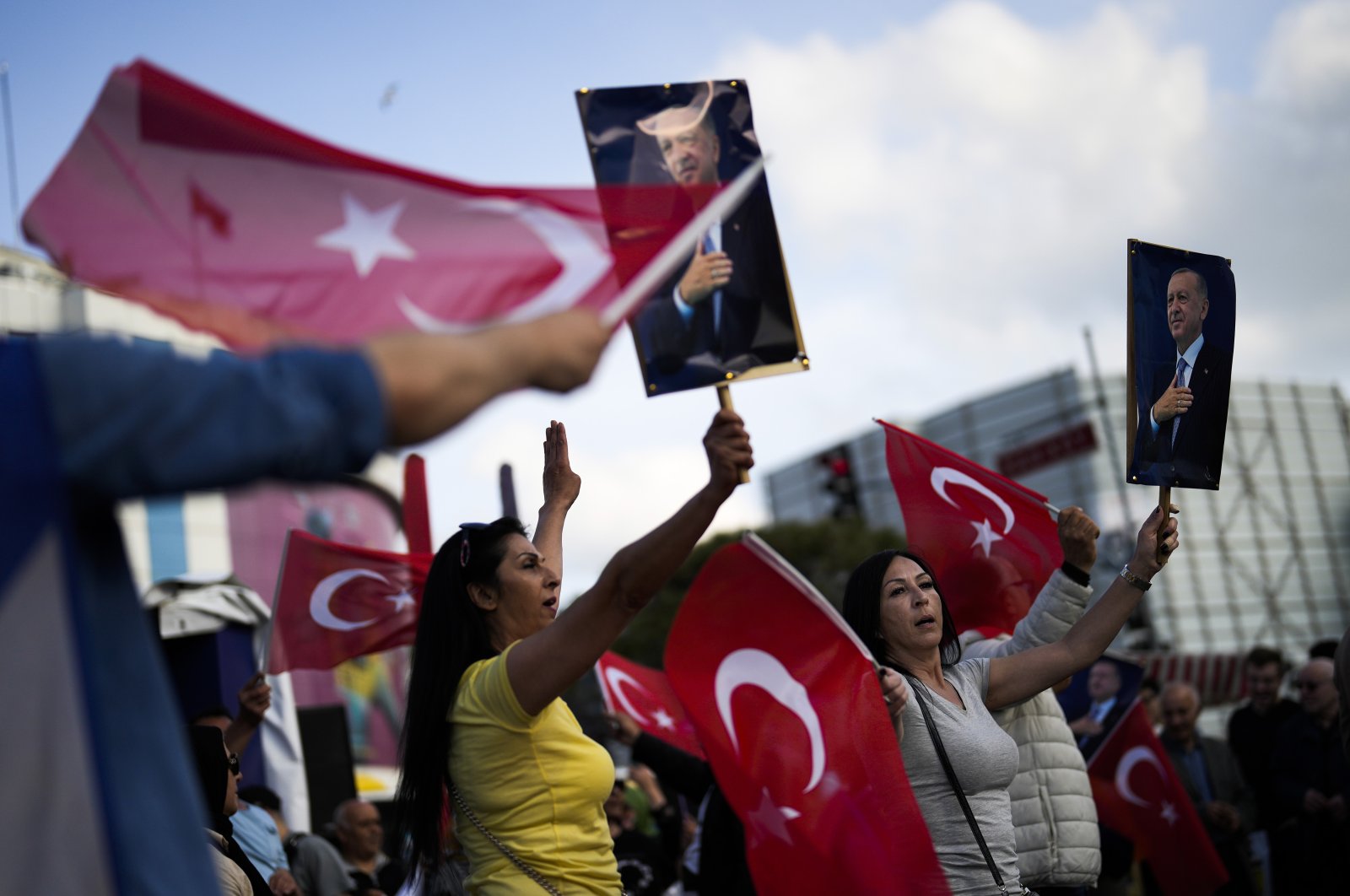 Supporters of President Recep Tayyip Erdoğan dance as they give handouts to commuters in Istanbul, Türkiye, May 23, 2023. (AP Photo)