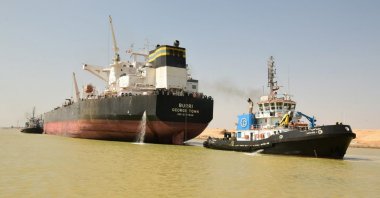 A tug boat pulls the Burri (L), an oil tanker flying the Cayman Island flag, after a collision with the Singapore-flagged BW Lesmes carrying LNG (not pictured), the Suez Canal, near the city of Suez, Egypt, Aug. 23, 2023. (Handout by the Suez Canal Authority via EPA Photo)