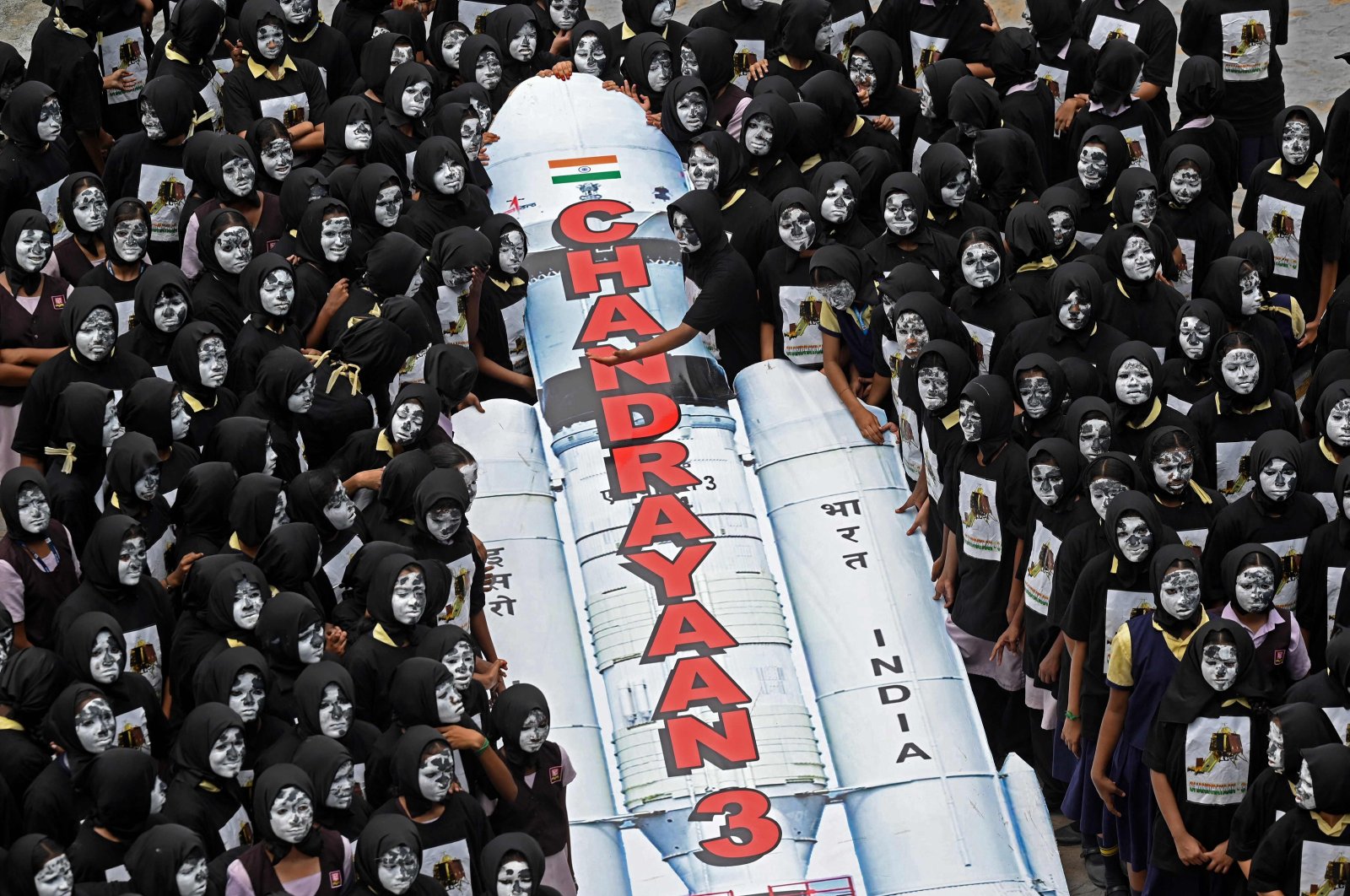 Students with painted faces surround a replica of the Chandrayaan-3 spacecraft in Chennai, India,  Aug. 22, 2023. (AFP Photo)