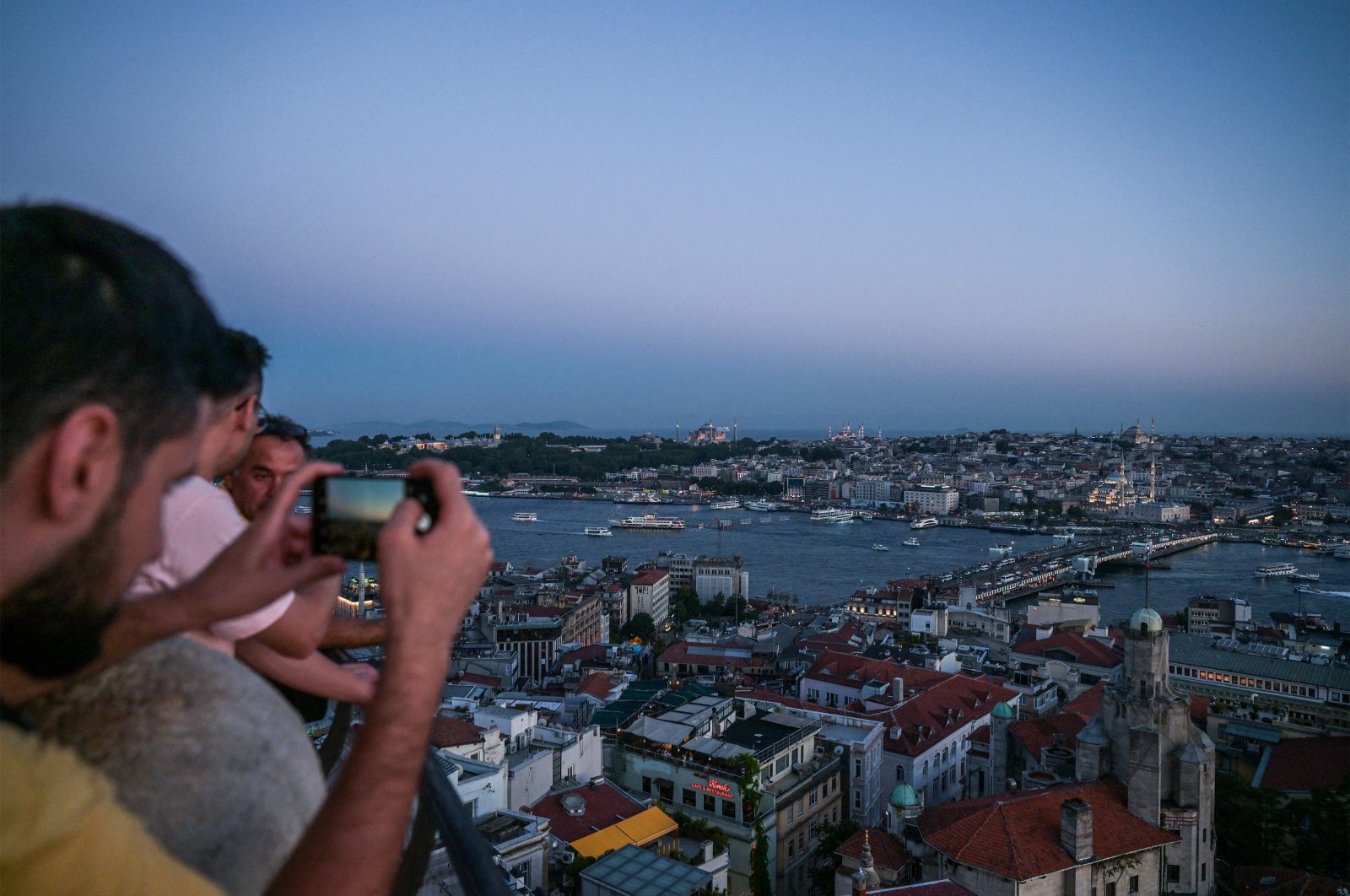 A tourist snaps a picture from the top of the landmark Galata Tower in Istanbul, Türkiye,  Aug. 4, 2023. (AFP Photo)