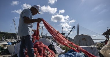 A fisherman loads a net on a boat, Istanbul, Türkiye, Aug. 27, 2023. (AA Photo)