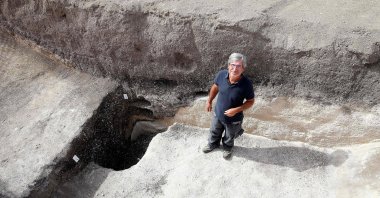 Remi Martineau, researcher at the CNRS, stands at the mouth of a well, dating from the Modern Neolithic, around 3,500 years ago, from a settlement suggesting the presence of a village occupied by a structured population, at Val-des-Marais, France, Aug. 23, 2023. (AFP Photo)