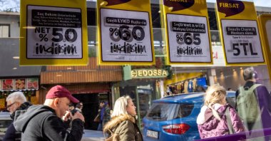People walk past a shop advertising sales in Istanbul, Türkiye, Jan. 19, 2023. (Reuters Photo)