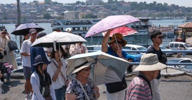 Tourists walk with umbrellas on a hot summer day in Istanbul, Türkiye, July 13, 2023. (EPA Photo)