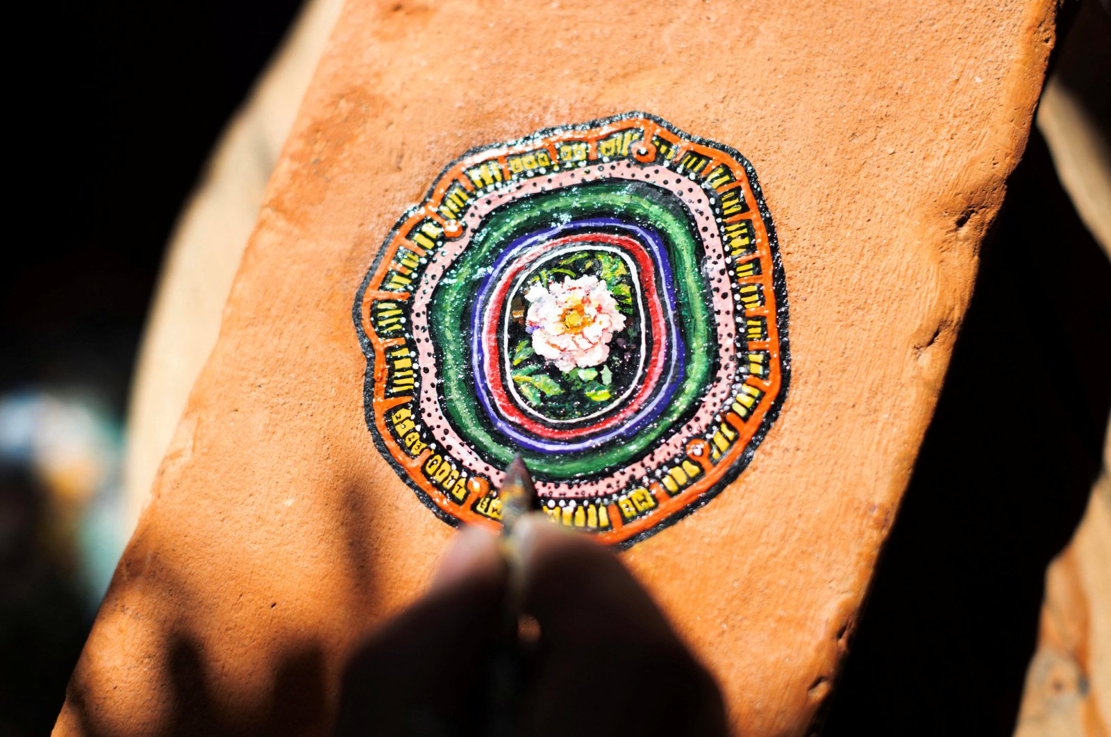 Ben Wilson shows his painting on a piece of chewing gum, stuck on a brick, in his home studio in Muswell Hill, London, U.K., Aug. 21, 2023. (Reuters Photo)