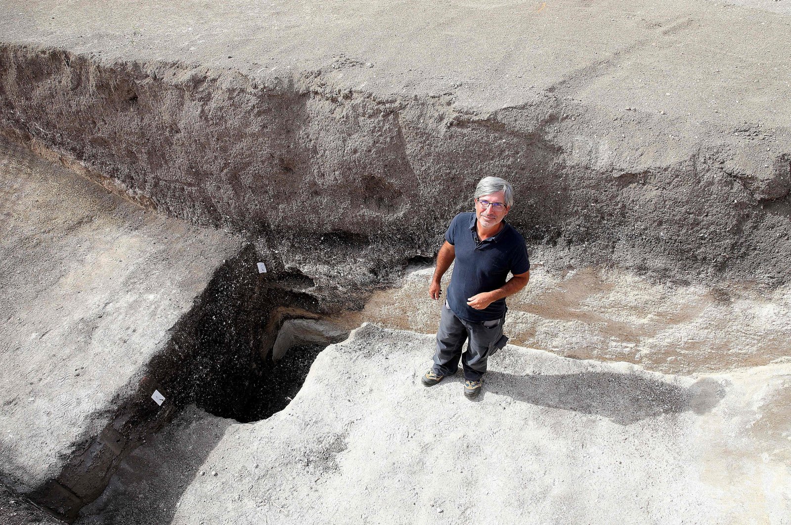 Remi Martineau, researcher at the CNRS, stands at the mouth of a well, dating from the Modern Neolithic, around 3,500 years ago, from a settlement suggesting the presence of a village occupied by a structured population, at Val-des-Marais, France, Aug. 23, 2023. (AFP Photo)