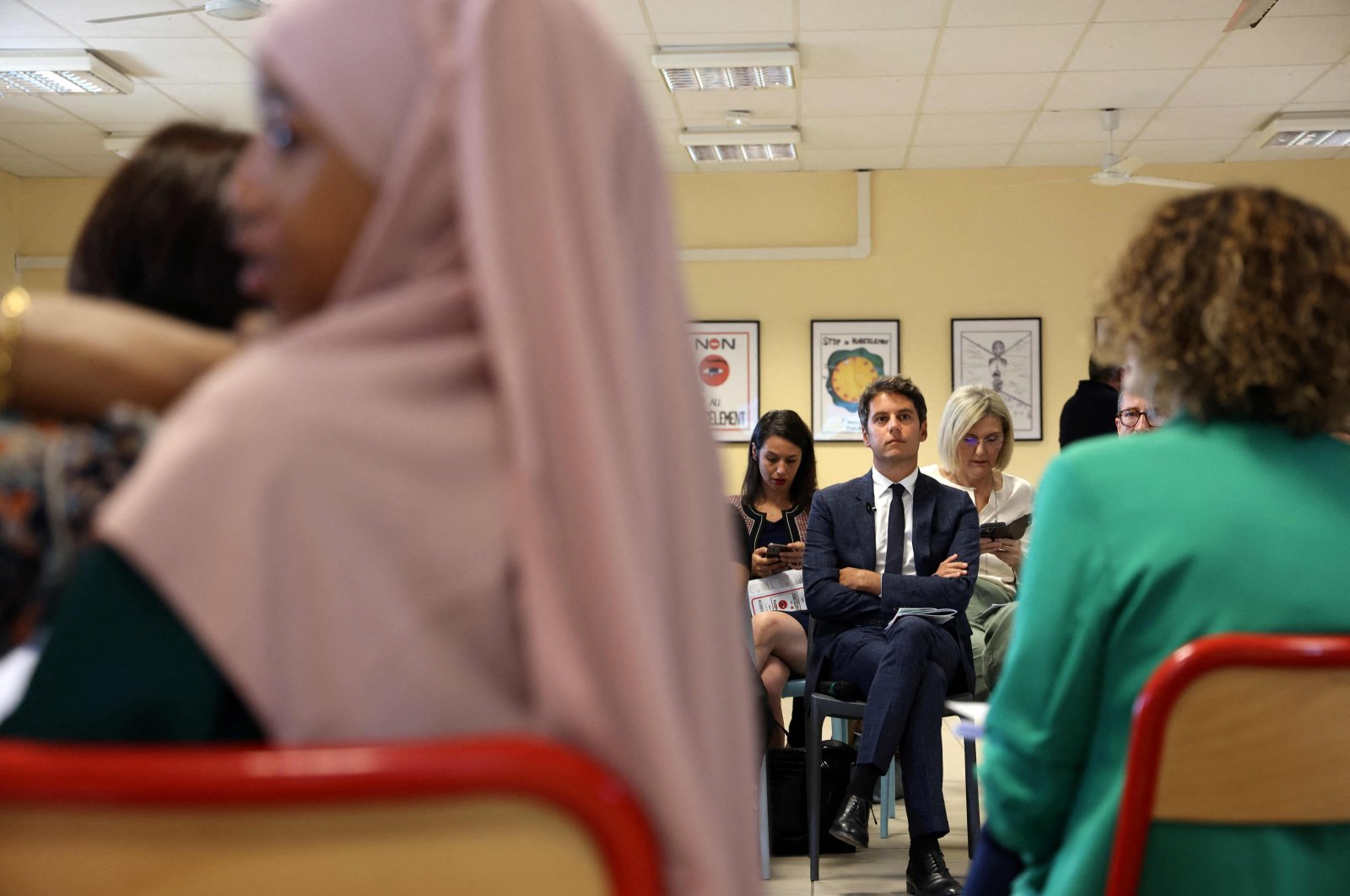 French Education Minister Gabriel Attal (C) attends a meeting at a school in Saint-Denis-de-la-Reunion, France, Aug. 17, 2023. (AFP Photo)