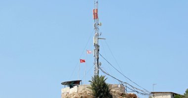 Turkish and Turkish Republic of Northern Cyprus (TRNC) flags flutter in Pile village, which lies between the Greek Cypriot administration in the south and the TRNC in the north, Aug. 20, 2023. (AFP Photo)